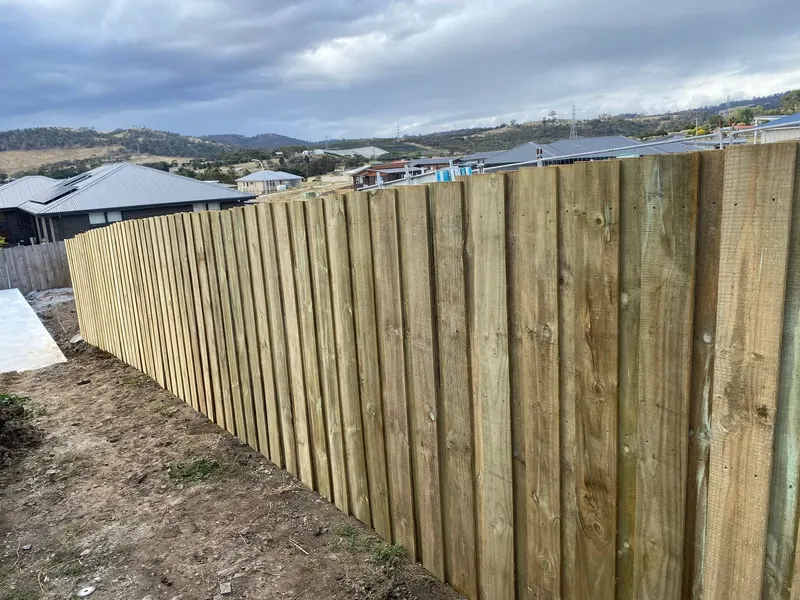 Long treated-pine paling fence on a new estate