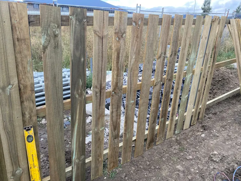 Palings fixed to rails with a spirit level against them